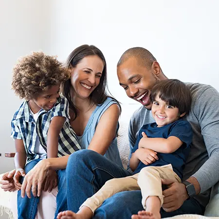 a man and woman sitting on a couch with children