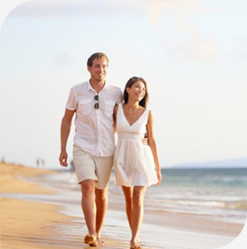 a man and woman walking on a beach