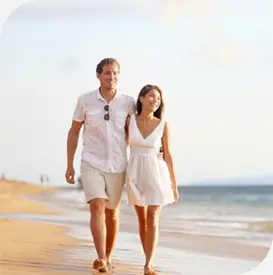 a man and woman walking on a beach